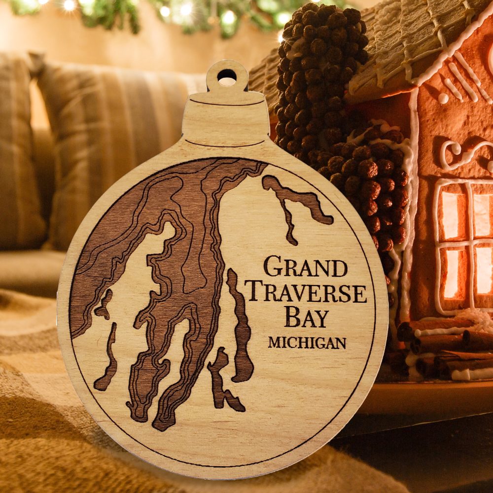 Grand Traverse Engraved Nautical Ornament Sitting on Table with Gingerbread House