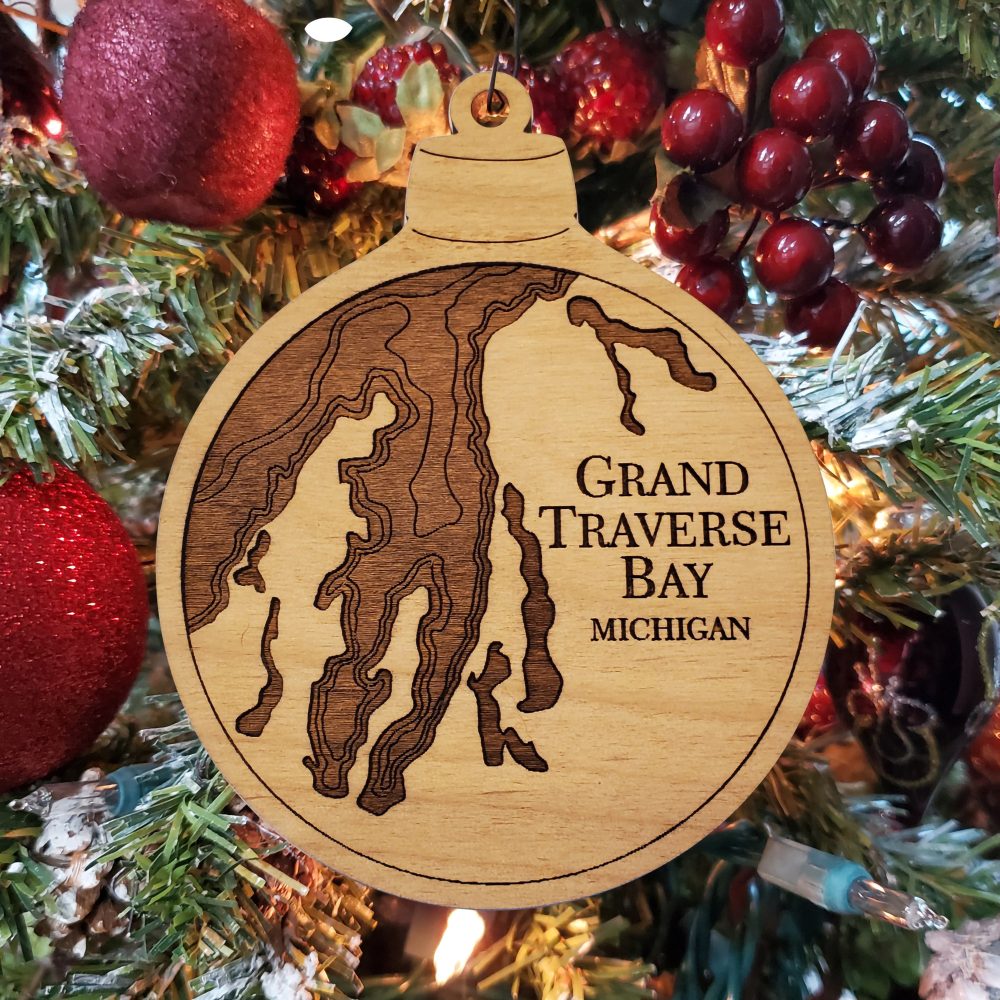 Grand Traverse Engraved Nautical Ornament Hanging on Christmas Tree with Red Ornaments