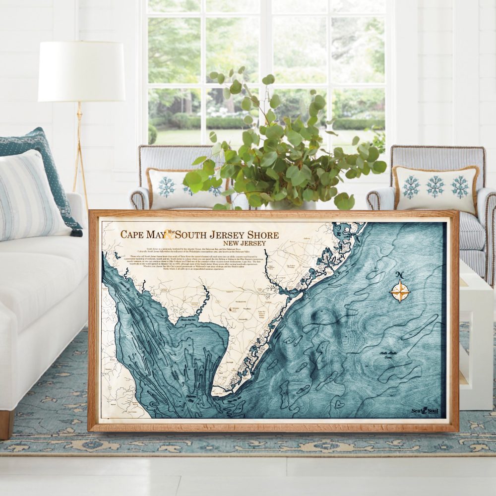 Cape May Nautical Map Wall Art Cherry Accent with Blue Green Water Sitting on Living Room Floor by Coffee Table