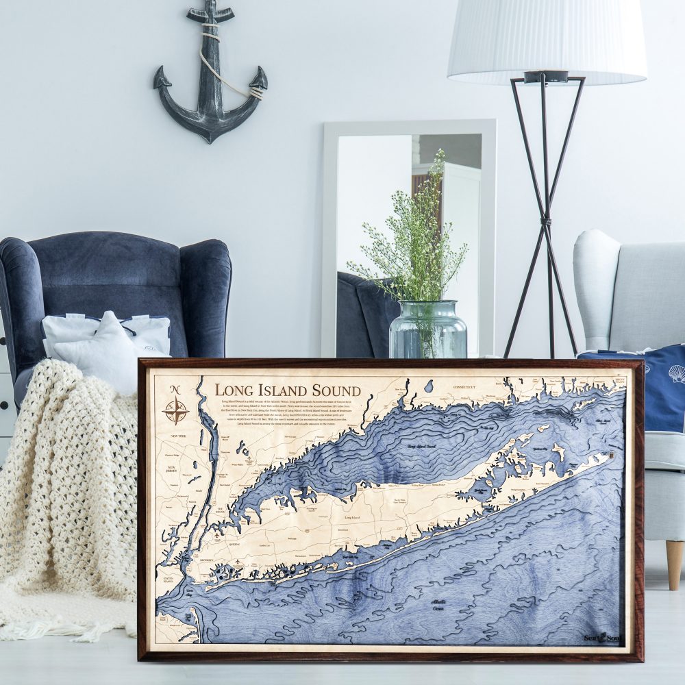 Long Island Sound Nautical Map Wall Art Walnut Accent with Deep Blue Water Sitting on Living Room Floor by Armchair