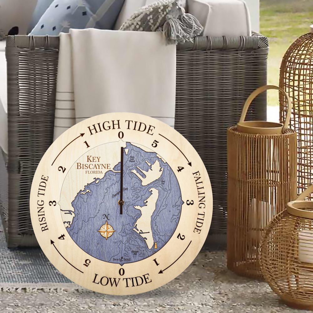 Key Biscayne Tide Clock Birch Accent with Deep Blue Water Sitting on Floor by Wicker Chair