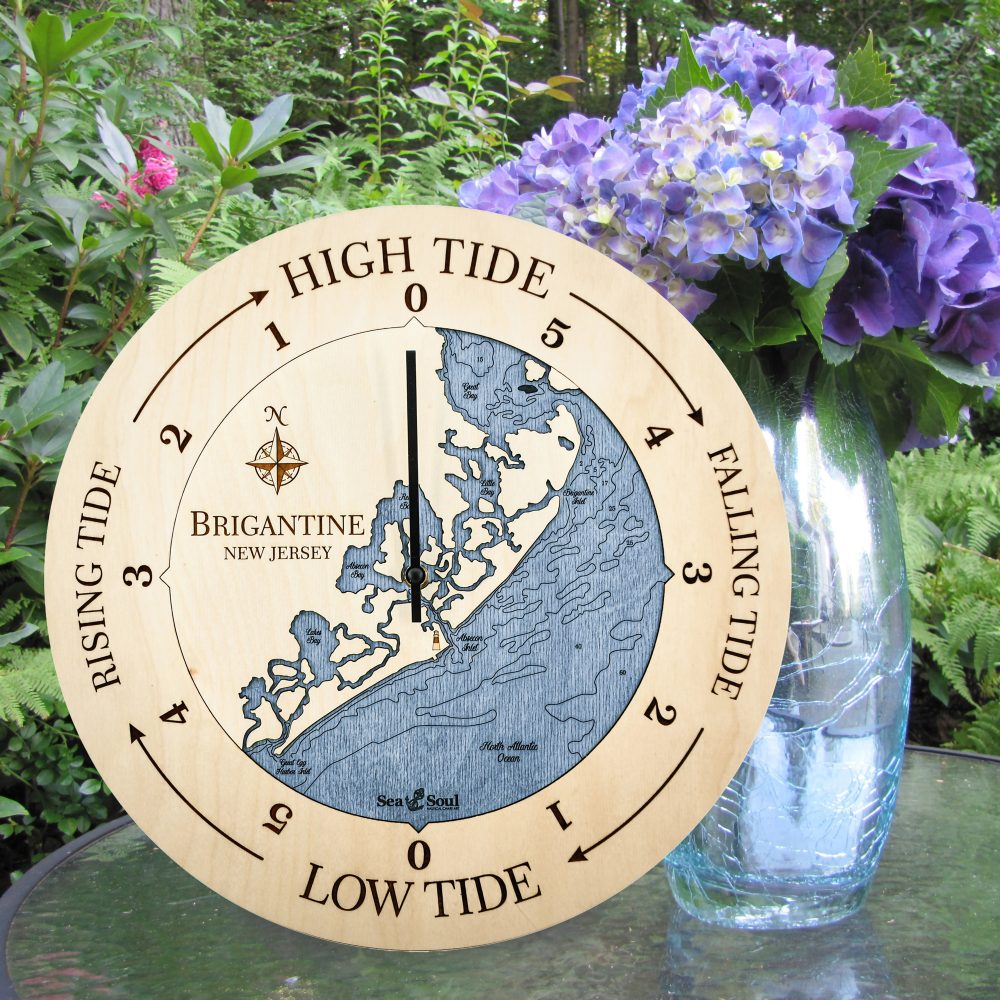 Brigantine Tide Clock Birch Accent with Deep Blue Water Sitting on Outdoor Table with Flowers