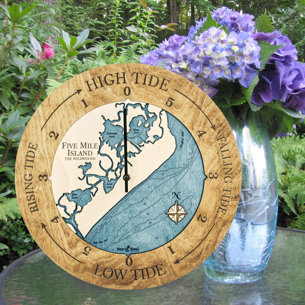 Five Mile Island Tide Clock Honey Accent with Blue Green Water Sitting on Outdoor Table with Flowers