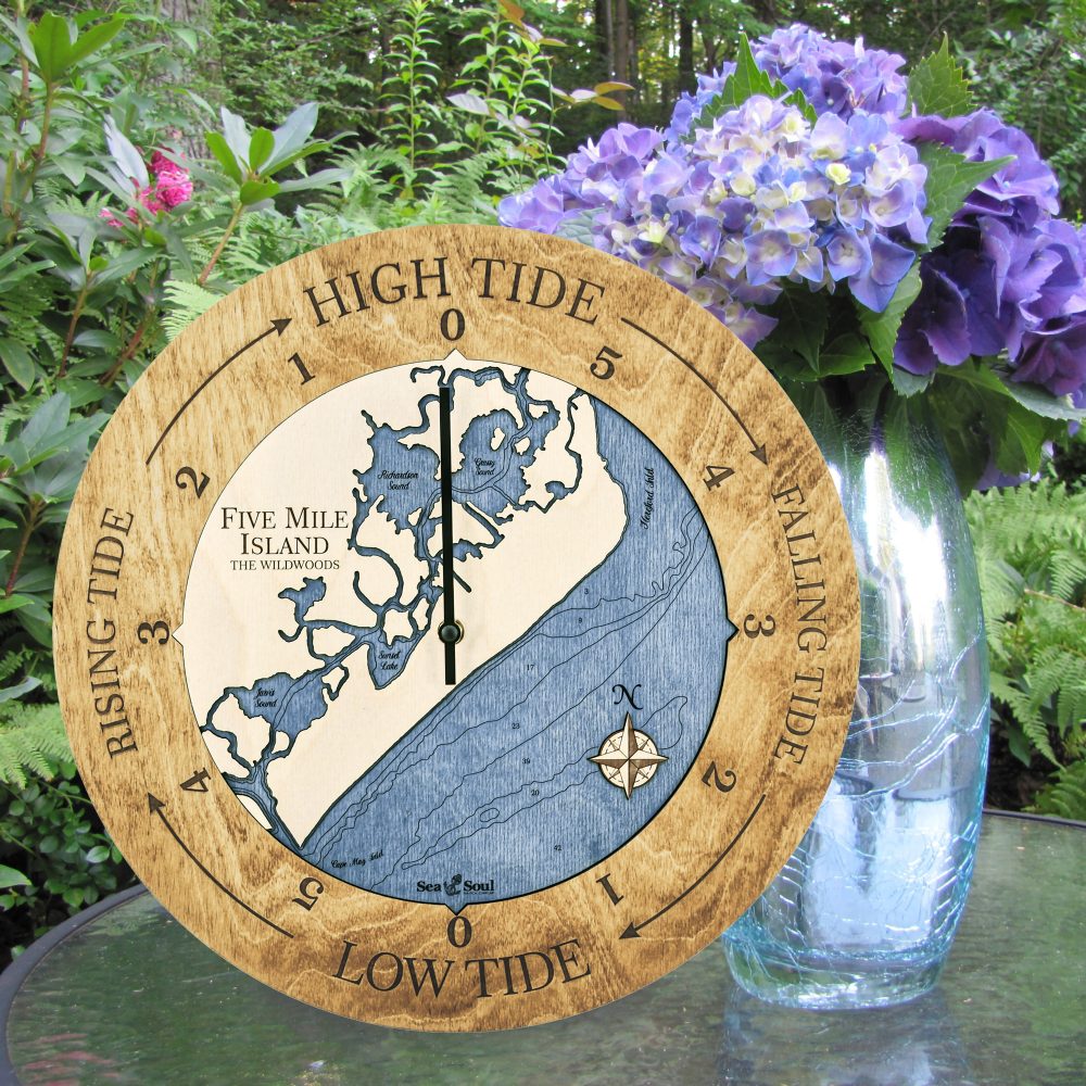 Five Mile Island Tide Clock Honey Accent with Deep Blue Water Sitting on Outdoor Table with Flowers
