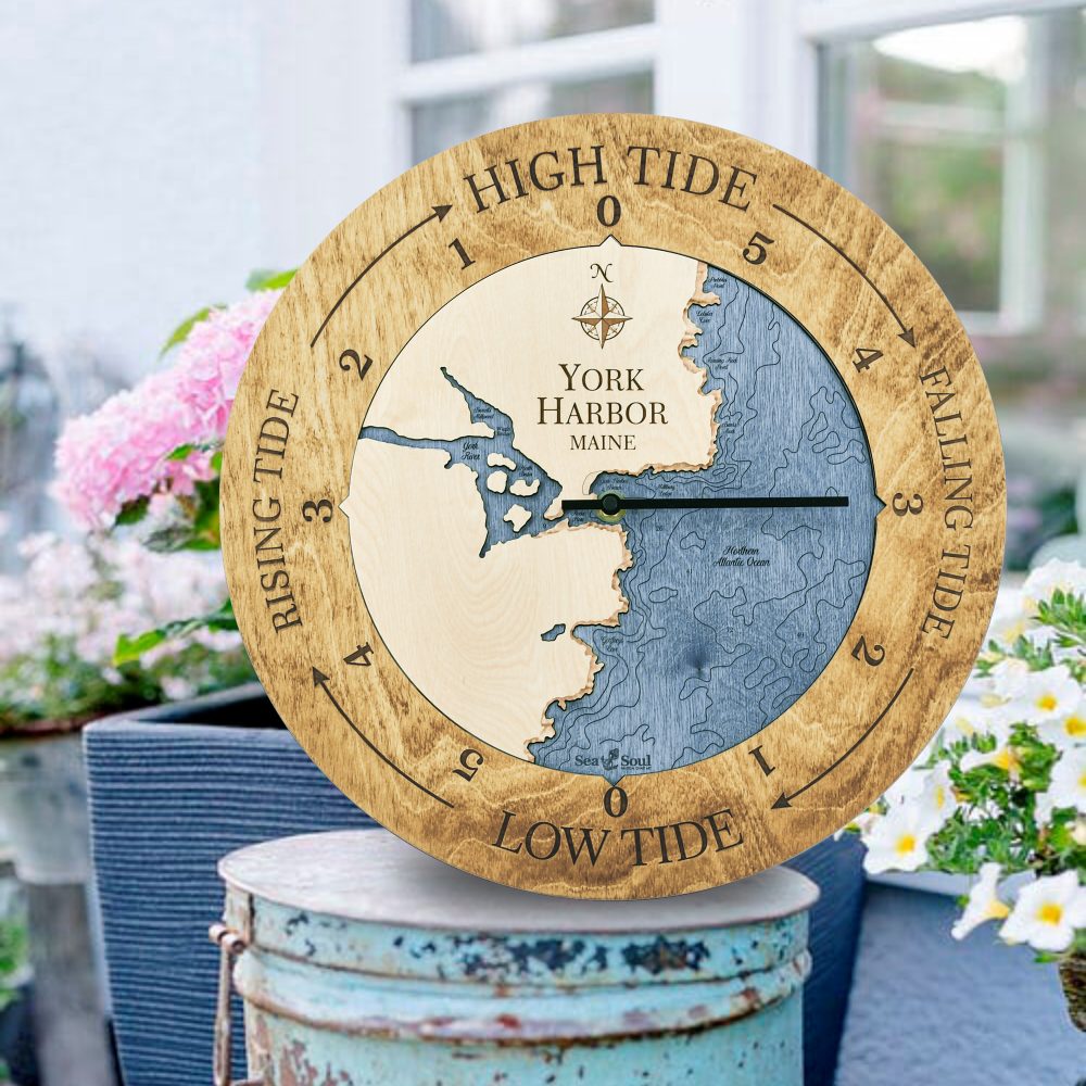York Harbor Tide Clock Honey Accent with Deep Blue Water Sitting on Bucket Outdoors by Flowers