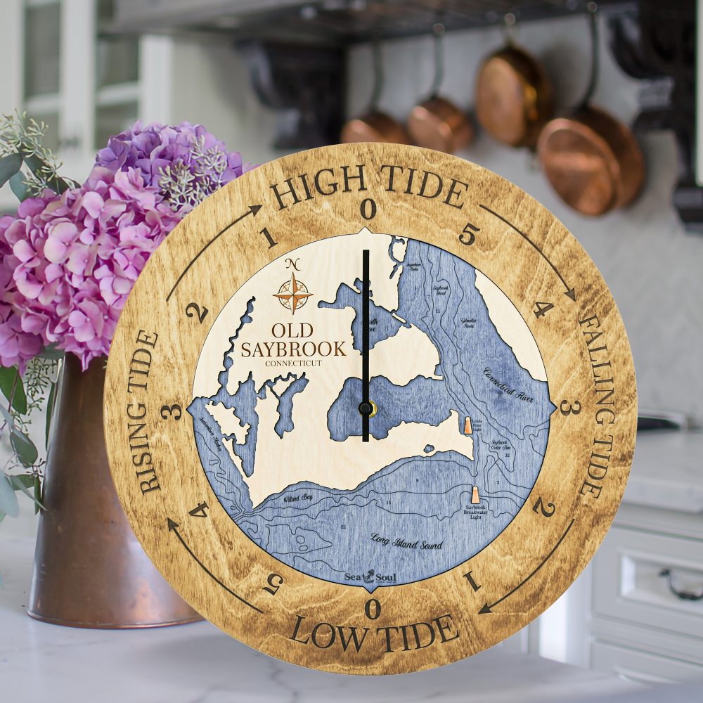 Old Saybrook Tide Clock Honey Accent with Deep Blue Water Sitting on Countertop with Flowers