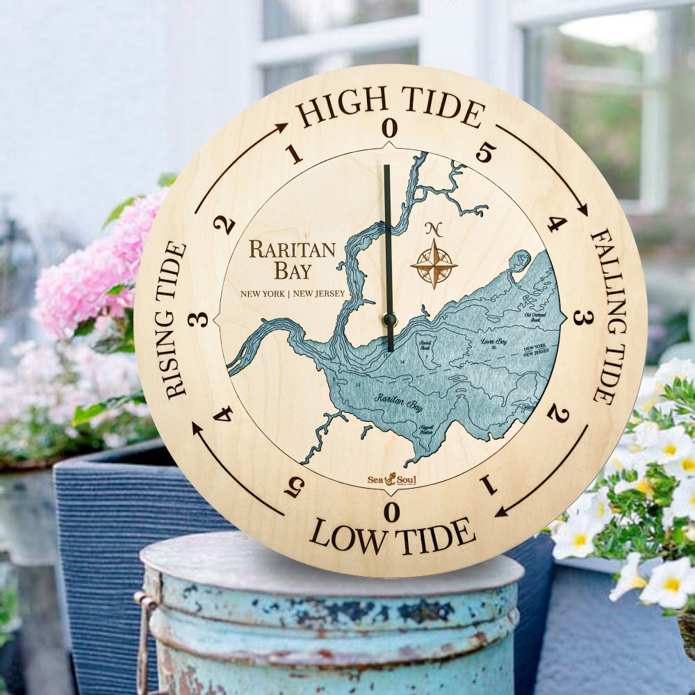 Raritan Bay Tide Clock Birch Accent with Blue Green Water Sitting on Bucket Outdoors by Flowers