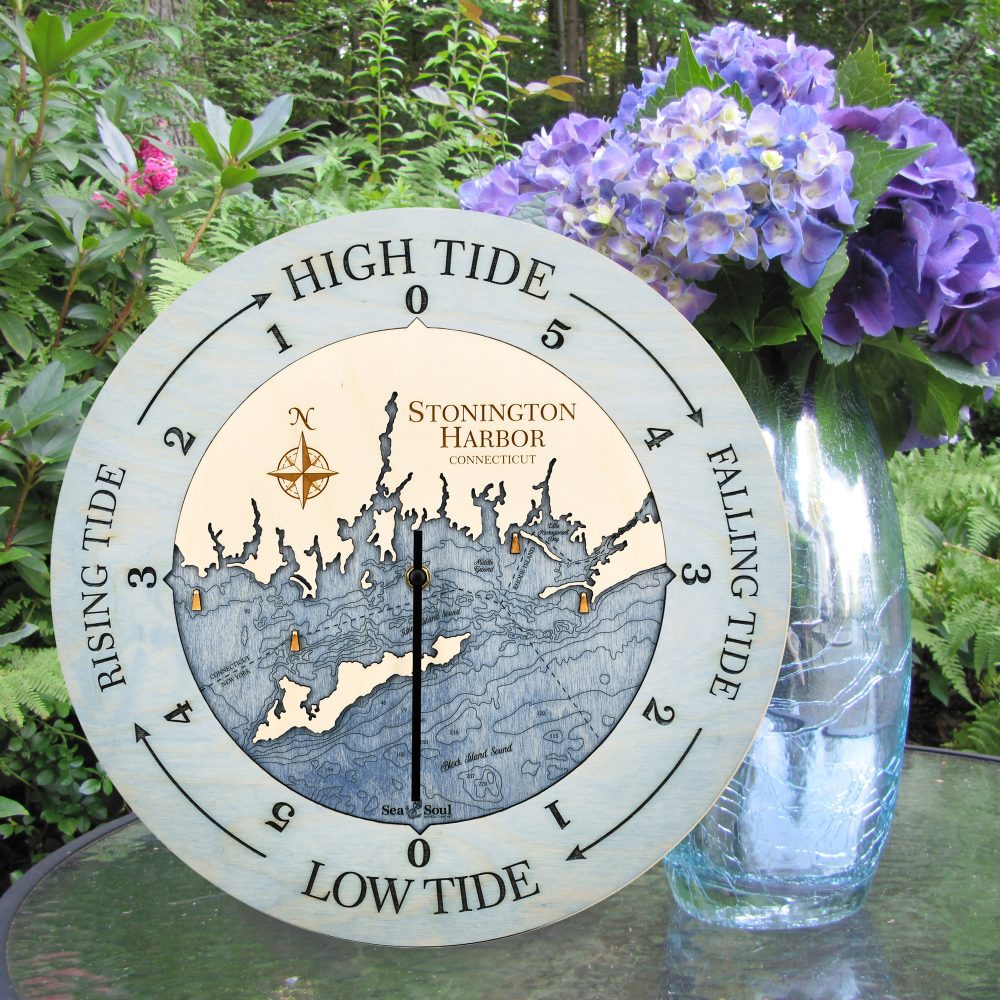 Stonington Harbor Tide Clock Bleach Blue Accent with Deep Blue Water Sitting on Outdoor Table with Flowers