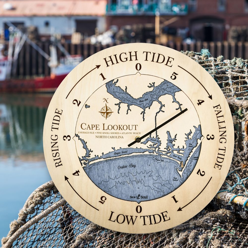 Cape Lookout Tide Clock Birch Accent with Deep Blue Water Sitting on Fishing Net by Waterfront