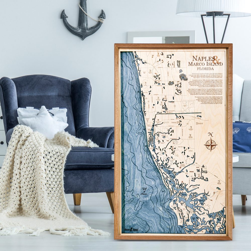 Naples Nautical Map Wall Art Cherry Accent with Deep Blue Water Sitting on Ground in Living Room by Armchair
