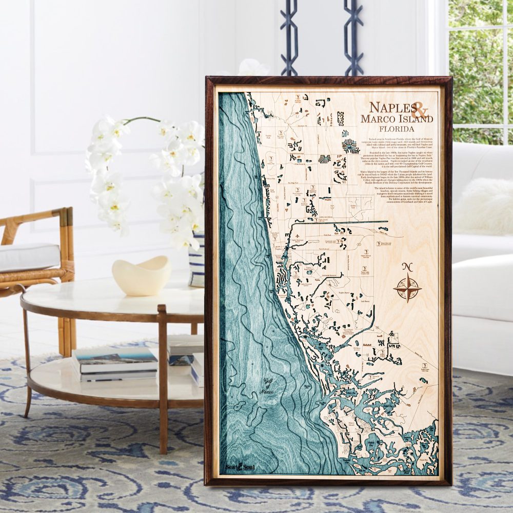 Naples Nautical Map Wall Art Walnut Accent with Blue Green Water Sitting on Living Room Floor by Coffee Table