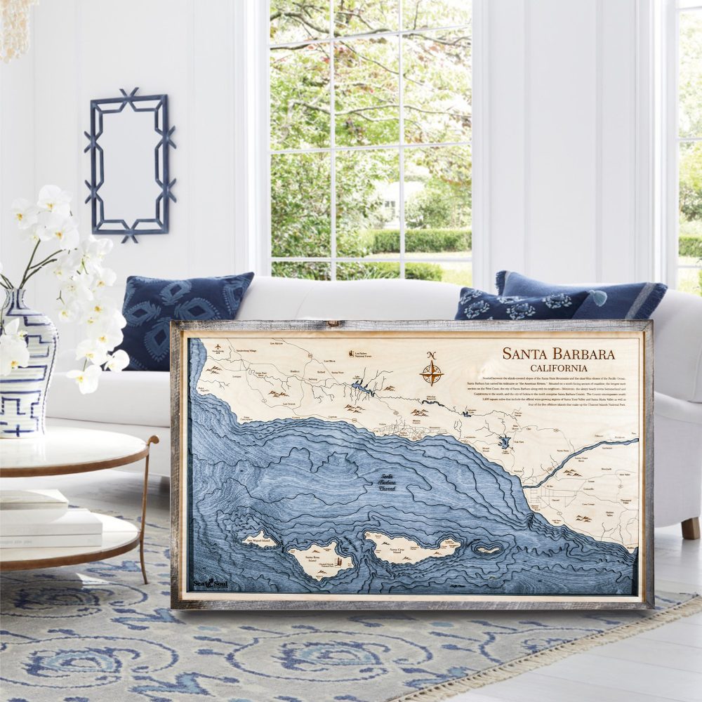 Santa Barbara Nautical Map Wall Art Rustic Pine Accent with Deep Blue Water Sitting on Living Room Floor by Coffee Table