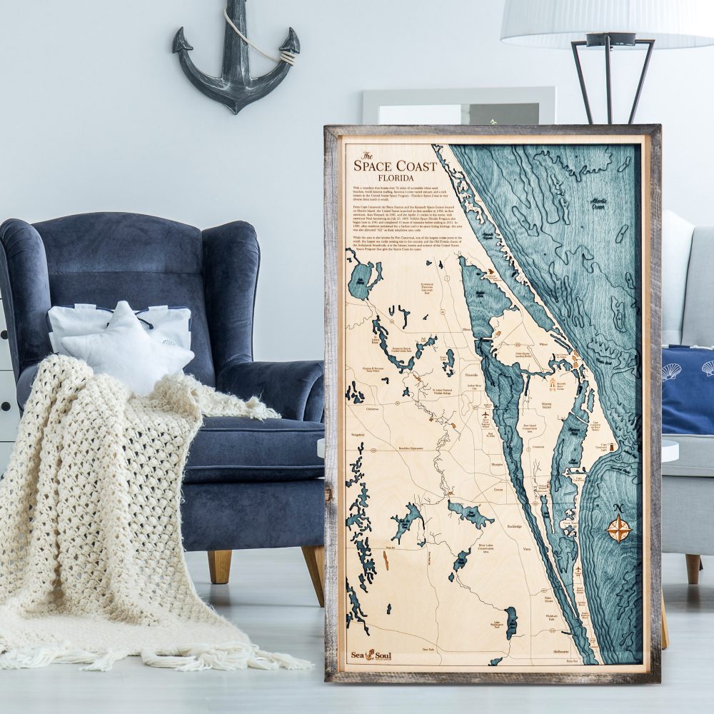 Space Coast Nautical Map Wall Art Rustic Pine Accent with Blue Green Water Sitting on Living Room Floor by Armchair