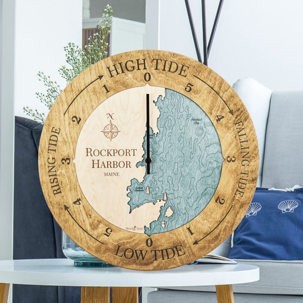 Rockport Harbor Tide Clock Honey Accent with Blue Green Water Sitting on Coffee Table