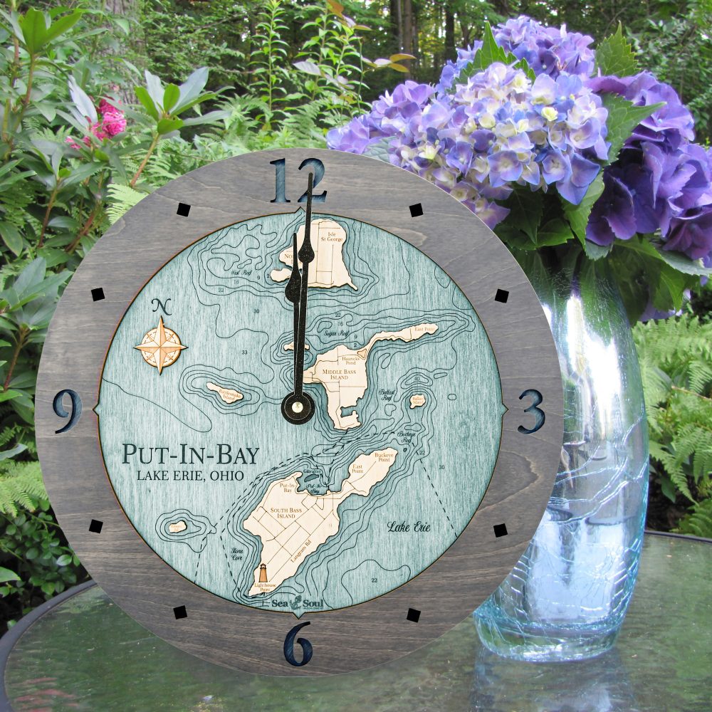 Put in Bay Nautical Clock Driftwood Accent with Blue Green Water Sitting on Outdoor Table by Flowers