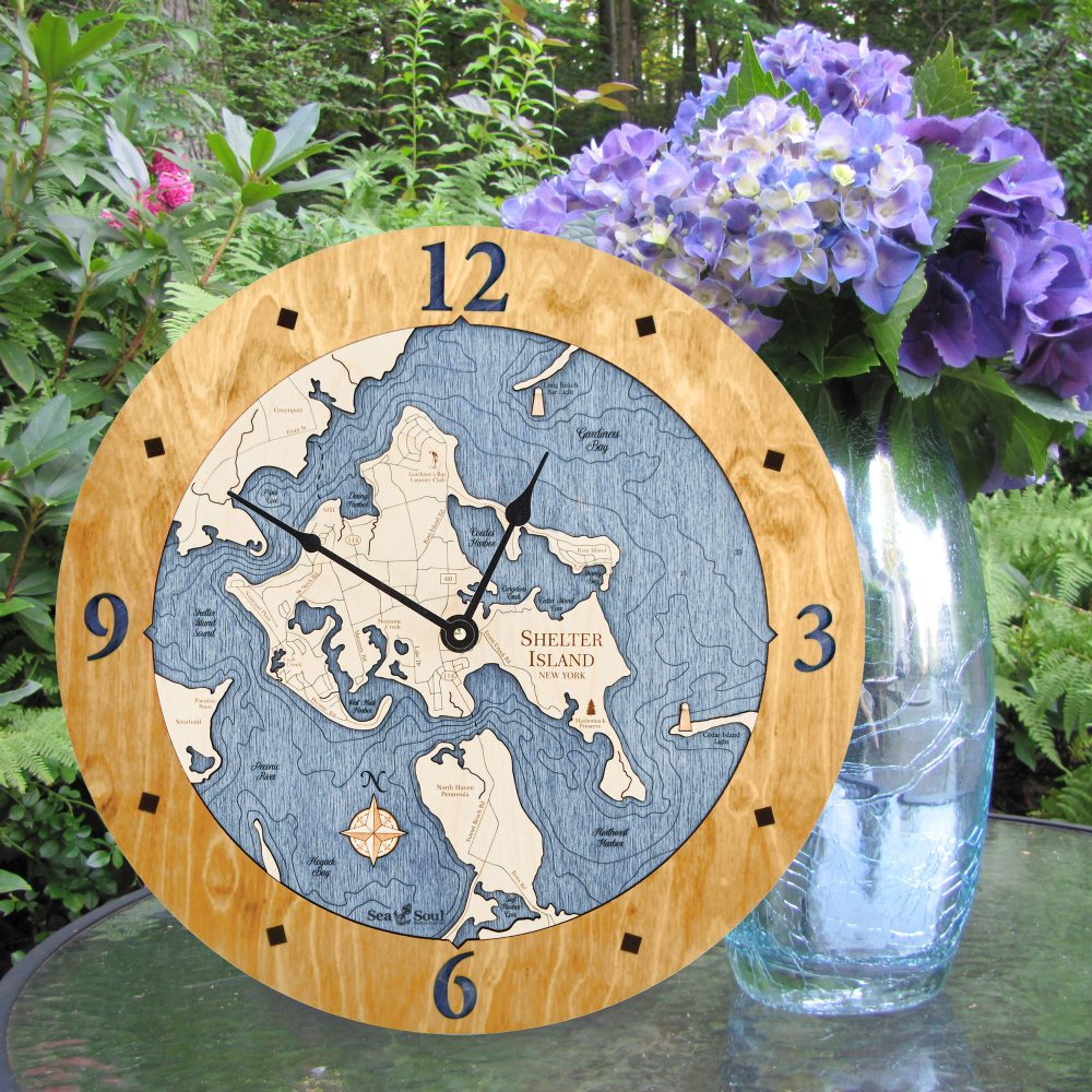Shelter Island Nautical Clock Honey Accent with Deep Blue Water Sitting on Outdoor Table by Flowers