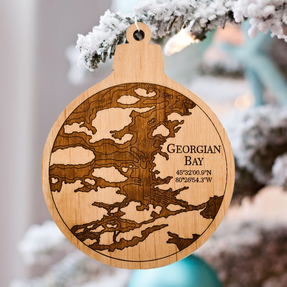 Georgian Bay Engraved Nautical Ornament Hanging on Outdoor Pine Tree with Snow