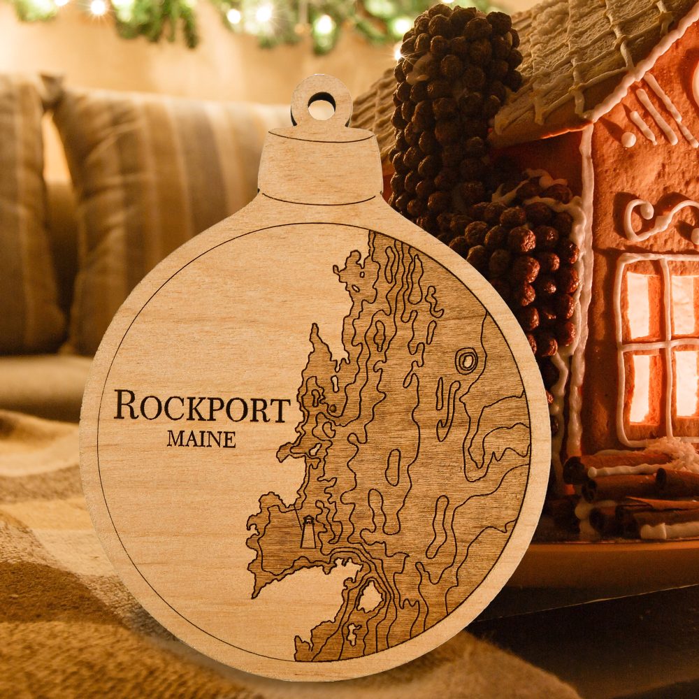 Rockport Engraved Christmas Ornament Sitting on Table with Gingerbread House