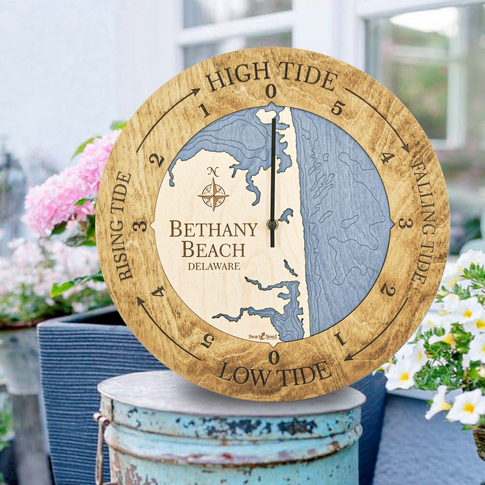 Bethany Beach Tide Clock Honey Accent with Deep Blue Water Sitting on Bucket Outdoors by Flowers